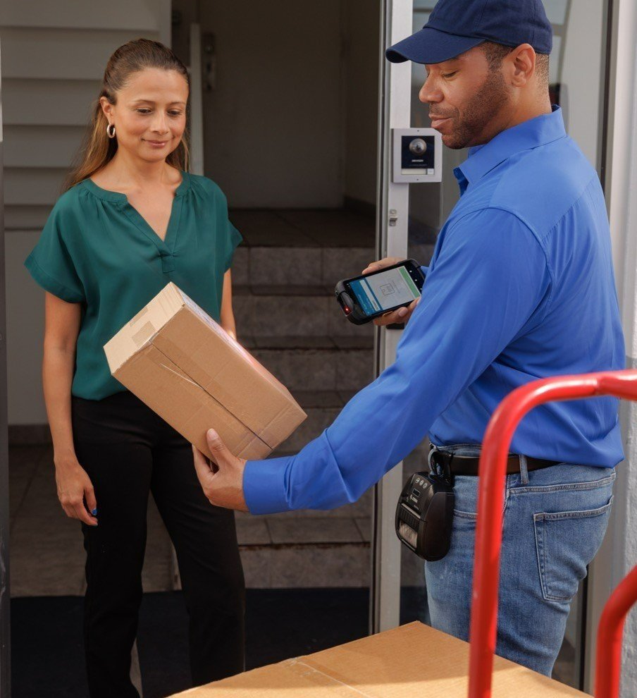 A man using a mobile computer to scan a parcel.