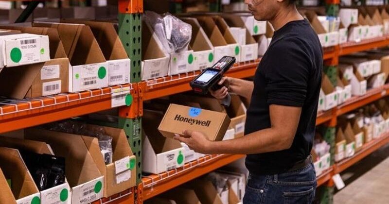 A warehouse worker using a CK67 rugged mobile computer to scan an item.