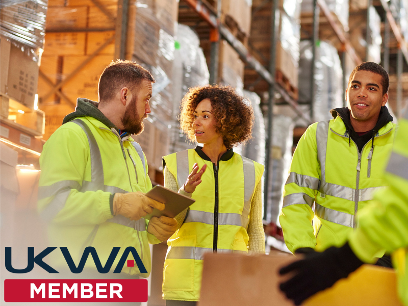A group of warehouse employees with the UKWA logo overlayed
