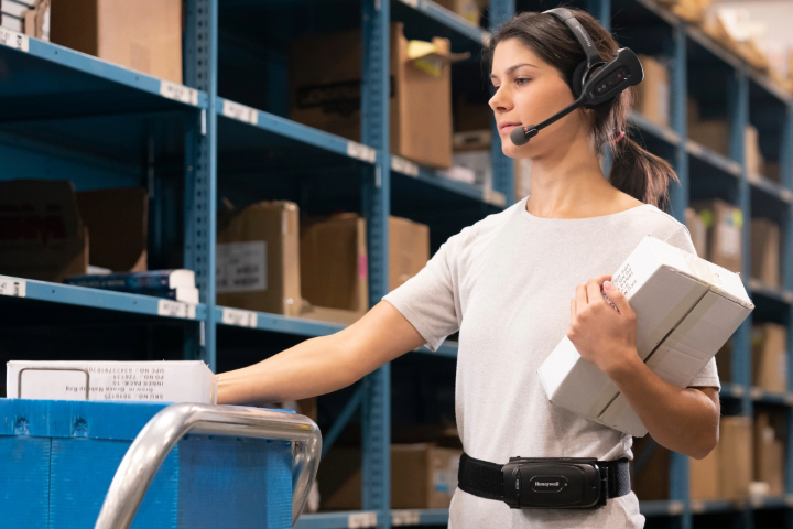 A warehouse worker using a wireless voice directed headset
