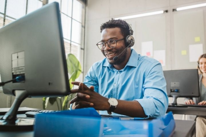 A tech support employee on a computer with headset